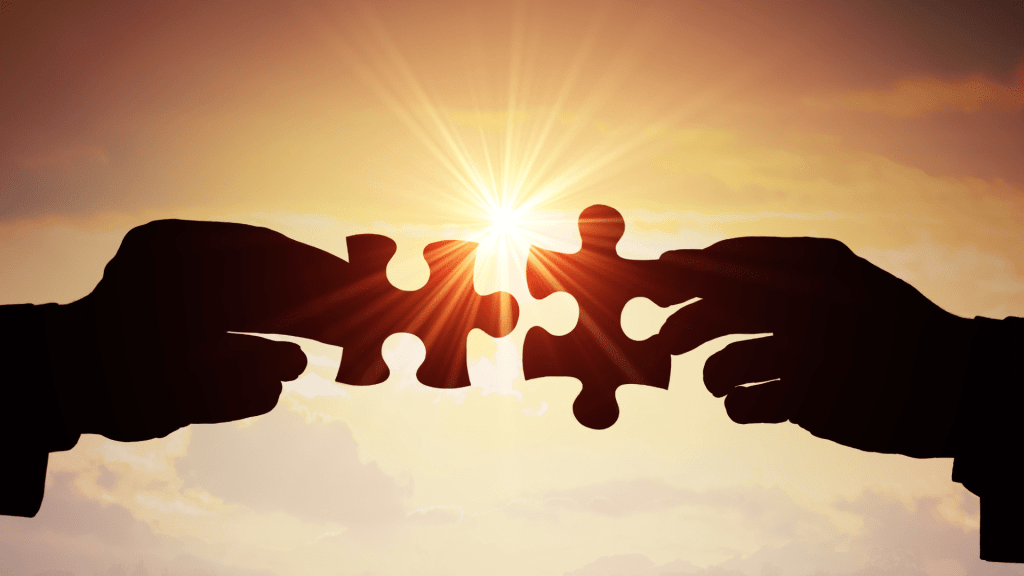 Image of two hands and two puzzle pieces