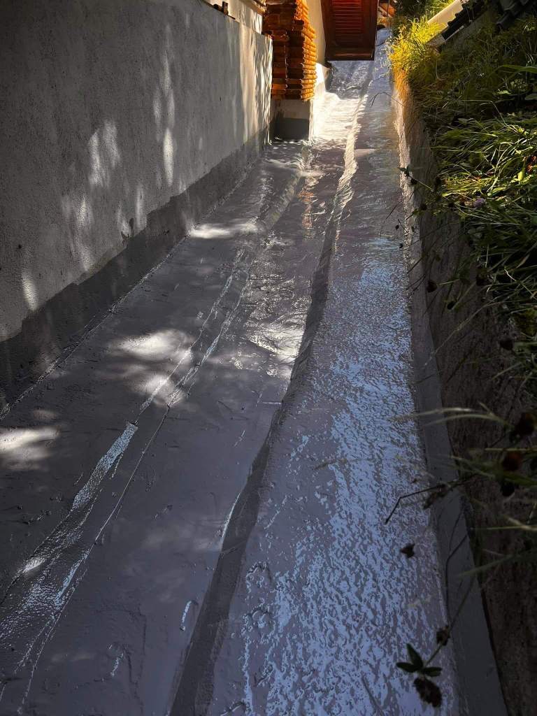 Image of a waterproofing operationbehind a house with liquid membrane